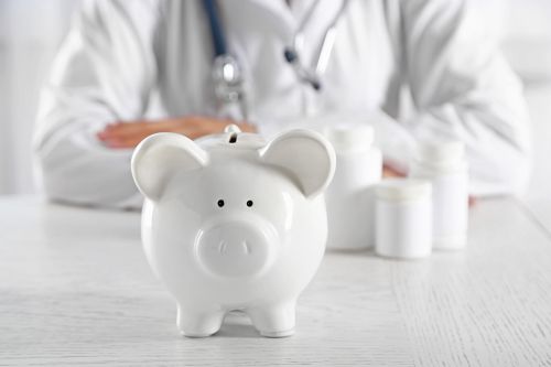 Foto: Arzt sitz hinter Sparschwein